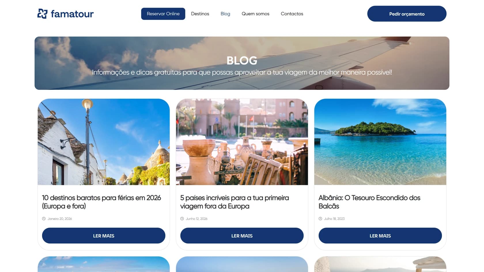 Página do blog da Famatour num ecrã de computador: o banner «BLOG» sobre a fotografia da asa de um avião ao pôr do sol, com a frase de apoio sobreposta, e por baixo três cartões de artigos lado a lado — cada um com fotografia, título, data e o botão Ler mais — e o topo da segunda fila de cartões a aparecer no fundo.